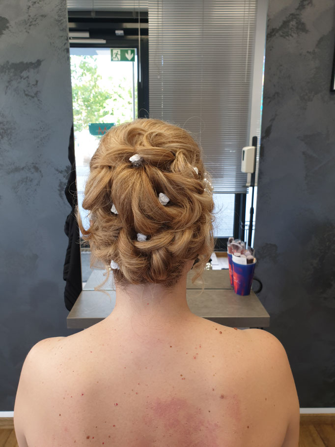 Brautfrisur mit weißen Blüten und weichen Wellen im Salon Ani